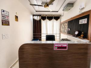 a reception desk in a room with a sign on it at Hotel Tree in Hisār +1 photo