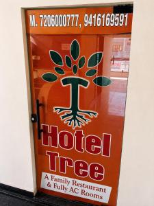 a door with a hotel tree sign on it at Hotel Tree in Hisār