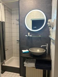 a bathroom with a sink and a mirror and a tub at De Post B&B Restaurant in Klimmen +34 photos
