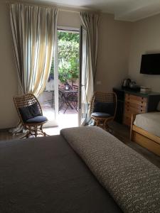 a bedroom with a bed and two chairs and a sliding glass door at B&B La Dimora Del Garda in Sirmione