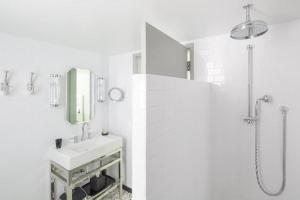 a white bathroom with a sink and a shower at COMO Metropolitan Miami Beach in Miami Beach +35 photos