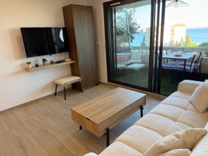 a living room with a couch and a tv at T2 "Bohême" vue mer, centre ville tout à pied in Le Lavandou