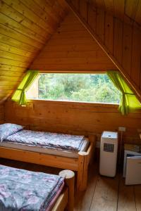 a room with two beds in a wooden cabin at Glamping Brodej in Vitanje