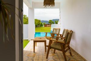 a table and chairs on a patio with a view of a pool at Meandros Boutique & Spa Hotel - Adults Only in Kalamaki