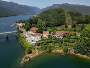 an island in the water with houses and a bridge at Beira Rio do Gerês in Geres