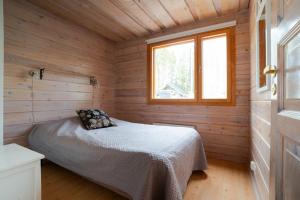 a bedroom with a bed in a wooden cabin at Villa Alli in Siikainen