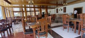 a dining room with wooden tables and chairs at Hunza Embassy Hotel by Zeez in Karimabad Hunza