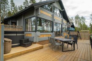 a house with a table and chairs on a deck at Villa Alli in Siikainen
