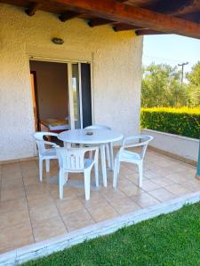 a white table and chairs on a patio at Kiparissis Apartments in Kriopigi
