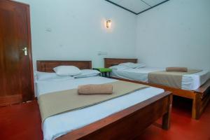 two beds in a room with two beds sidx sidx sidx at Zenvora Rainforest Villa in Deniyaya