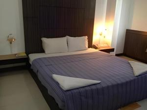 a large bed with white pillows in a bedroom at Senesouk Hotel in Vientiane