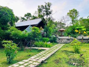 a garden with a walkway in front of a building at Mango Garden Eco Resort sigiriya in Sigiriya