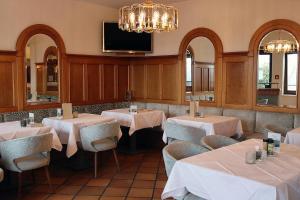 a restaurant with tables and chairs and a flat screen tv at THERMEN - APARTMENT BIODORF Bad Waltersdorf in Bad Waltersdorf