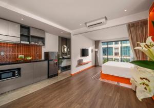 a bedroom with a bed and a kitchen at The Locals Hotel - Dinh Thi Hoa Da Nang in Danang