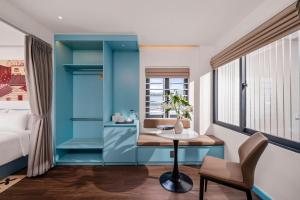 a room with a bed and a desk and a chair at The Locals Hotel - Dinh Thi Hoa Da Nang in Danang