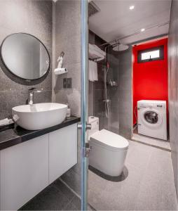 a bathroom with a sink and a toilet and a washing machine at The Locals Hotel - Dinh Thi Hoa Da Nang in Danang +22 photos