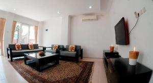 a living room with couches and a flat screen tv at Cozzy Seaview Beach Resort in Jepara