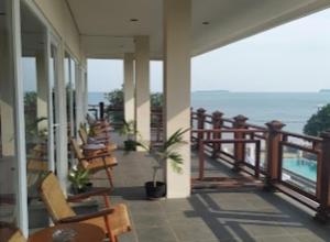 a balcony with chairs and a view of the ocean at Cozzy Seaview Beach Resort in Jepara