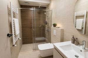 a bathroom with a shower and a toilet and a sink at NOCE Luxury Apartments in Ohrid +32 photos