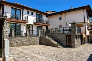 a building with a stone wall and stairs in front at NOCE Luxury Apartments in Ohrid