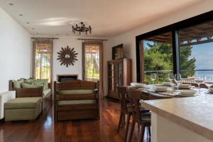 a dining room and living room with a table and chairs at The Quite Blue villa in Kriopigi