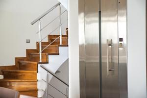 a staircase with a stainless steel door next to a stair case at The Quite Blue villa in Kriopigi