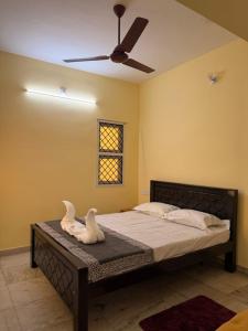 a bedroom with a bed with a ceiling fan at Villa Yogalakshmi in Chidambaram