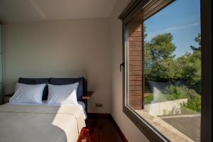a bedroom with a bed and a large window at The Quite Blue villa in Kriopigi