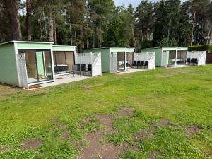 a row of green modular houses in a field at Teemeistri Camp in Tõrva +12 photos