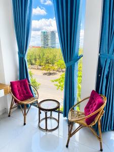 two chairs and a table in front of a window at VyVy House Hotel in Tuy Hoa