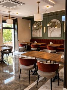 a dining room with wooden tables and chairs at Delmont hotel in Kostanay