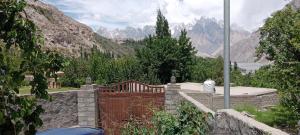 a man standing on a fence with mountains in the background at Mullberry Lodge Gulmit in Chamangul