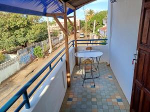 a balcony with a table and a view of a street at Hôtel chez Dan in Antsiranana