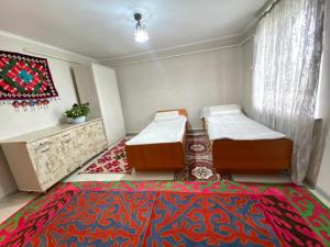 a room with two beds and a rug at Sun Garden Guest House in Ak-Say +9 photos