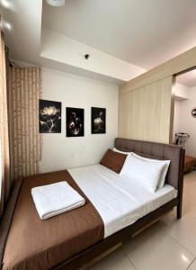 a bedroom with a large bed with two towels on it at Sea Residences Sunset Point in Manila +122 photos