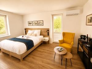 a bedroom with a bed and a yellow chair at Boutique Hotel at Golf Piestany in Piešťany