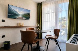 a room with a table and chairs and a large window at NOCE Luxury Apartments in Ohrid