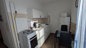 a small kitchen with a stove and a refrigerator at Magaslak Apartman in Kaposvár +17 photos