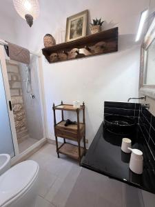 a bathroom with a toilet and a black counter at Asparano in Ognina