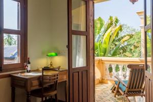 a room with a desk and a table and a window at Le Relais de Chhlong in Chhlong