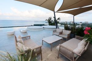 a patio with chairs and tables and an umbrella at Diane Homes Evoque nyali in Mombasa