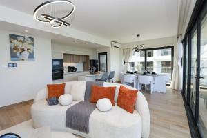 a living room with a white couch and a kitchen at Diane Homes Evoque nyali in Mombasa