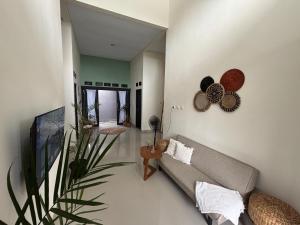 a living room with a couch and a plant at Secretspot Yogyakarta in Yogyakarta