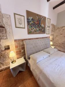 a bedroom with a bed and a table with a lamp at Asparano in Ognina