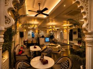 a lobby of a restaurant with tables and chairs at Kaner Bagh A Heritage Boutique Hotel in Udaipur