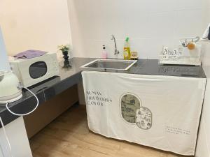 a kitchen with a table with a sign on it at Amin Studio Apartment Pool And Netflix in Gua Musang