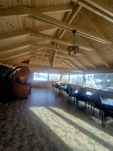 a room with wooden ceilings and tables and chairs at Cabana La Aurel in Subcetate