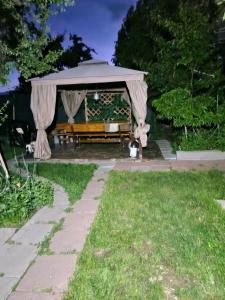 a gazebo with a bench in a yard at apartament maia 2 in Turda