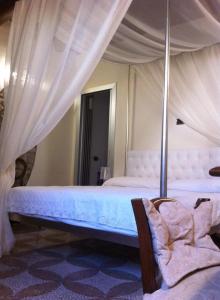 a bedroom with a canopy bed with a chair at B&B Al Convento in Potenza