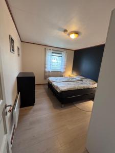 a bedroom with a bed and a black wall at Rent Apartament Lofoten in Svolvær